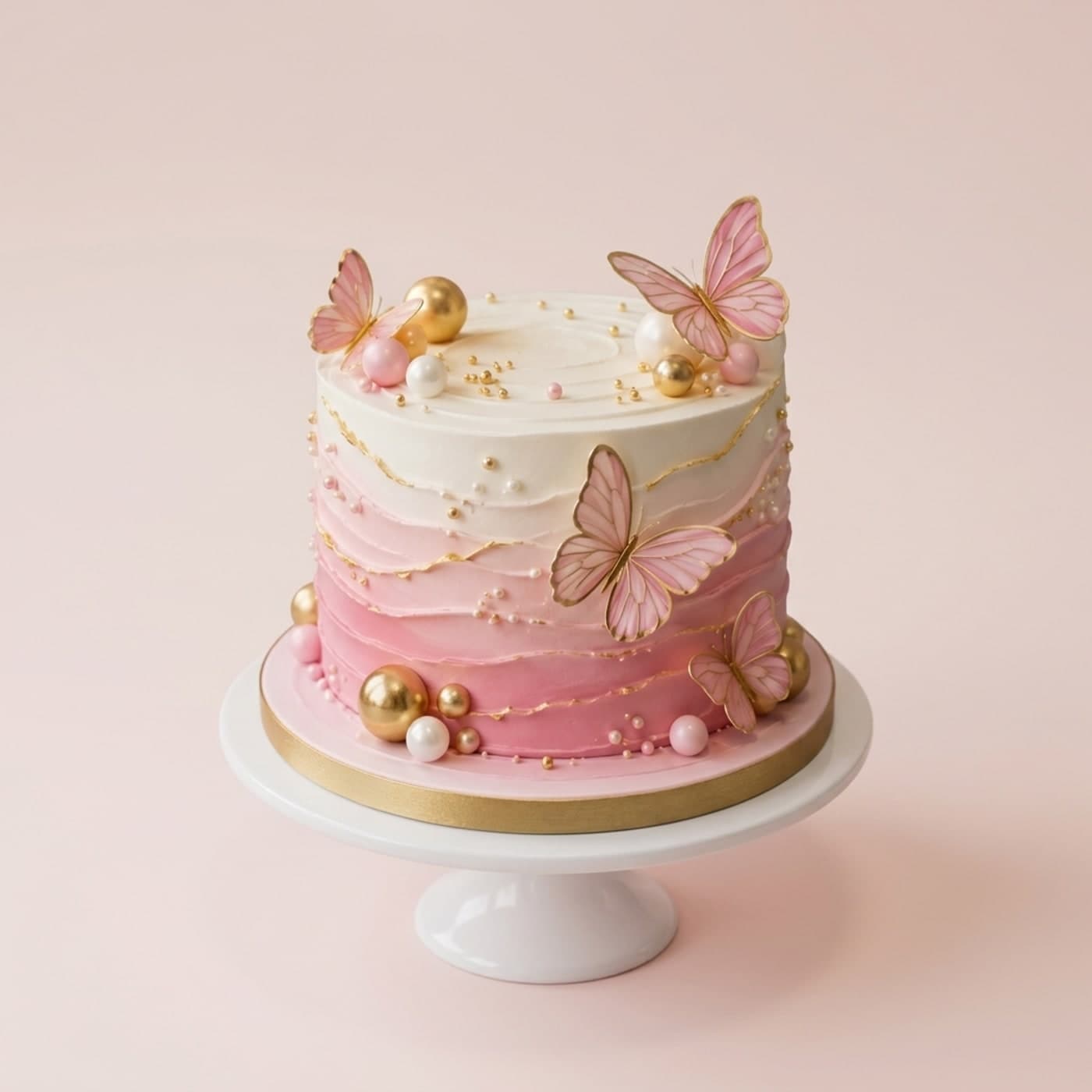 Beyaz stantta pembe ombre, altın detaylı ve kelebek süslemeli katlı pasta